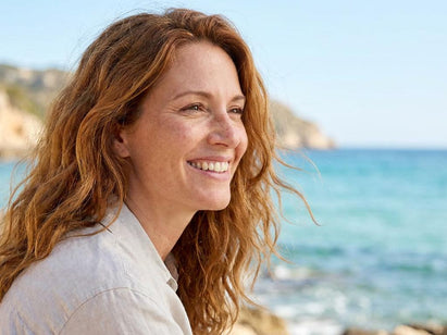 woman sitting on a beach looking out to sea