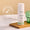 En hvit flaske Green People Day Solution Cream SPF15 står på et trebrett ved siden av et riflet grønt glasskar.