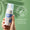 Hånd som holder en flaske Oy Clear Skin Foaming Face Wash mot lysegrønn bakgrunn, med et "Dermatologisk testet"-merke.