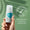 En hånd holder en flaske Oy Deodorant mot en myk grønn bakgrunn ved siden av et dermatologisk testet-merke.